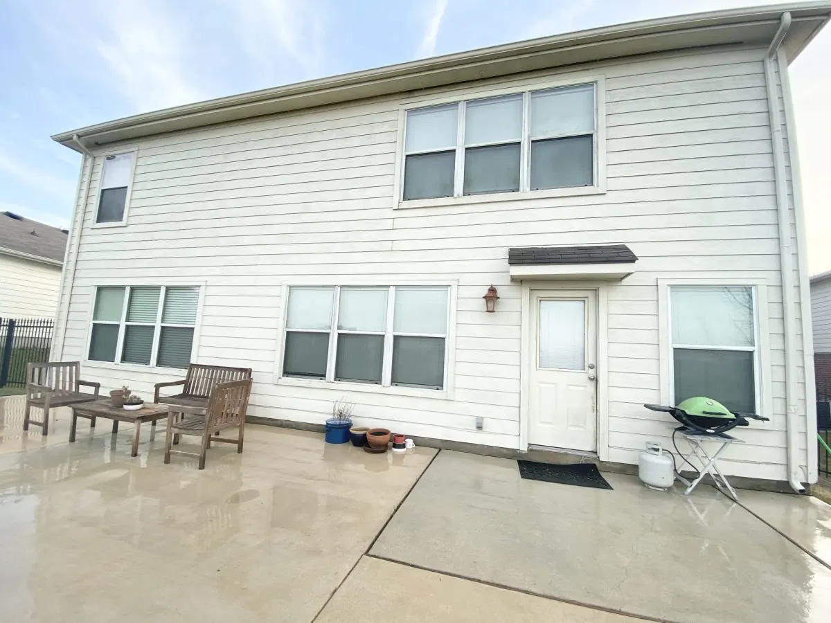 The same home with clean siding and patio